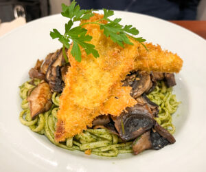 Vegan dinner at Végét’Halles in Paris, linguine tossed in a rich mushroom pesto and pan-fried breaded soy steak 